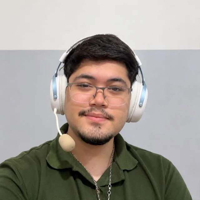 Nilmar Junior, fundador da Connexum, sorrindo, com headset branco e camisa verde